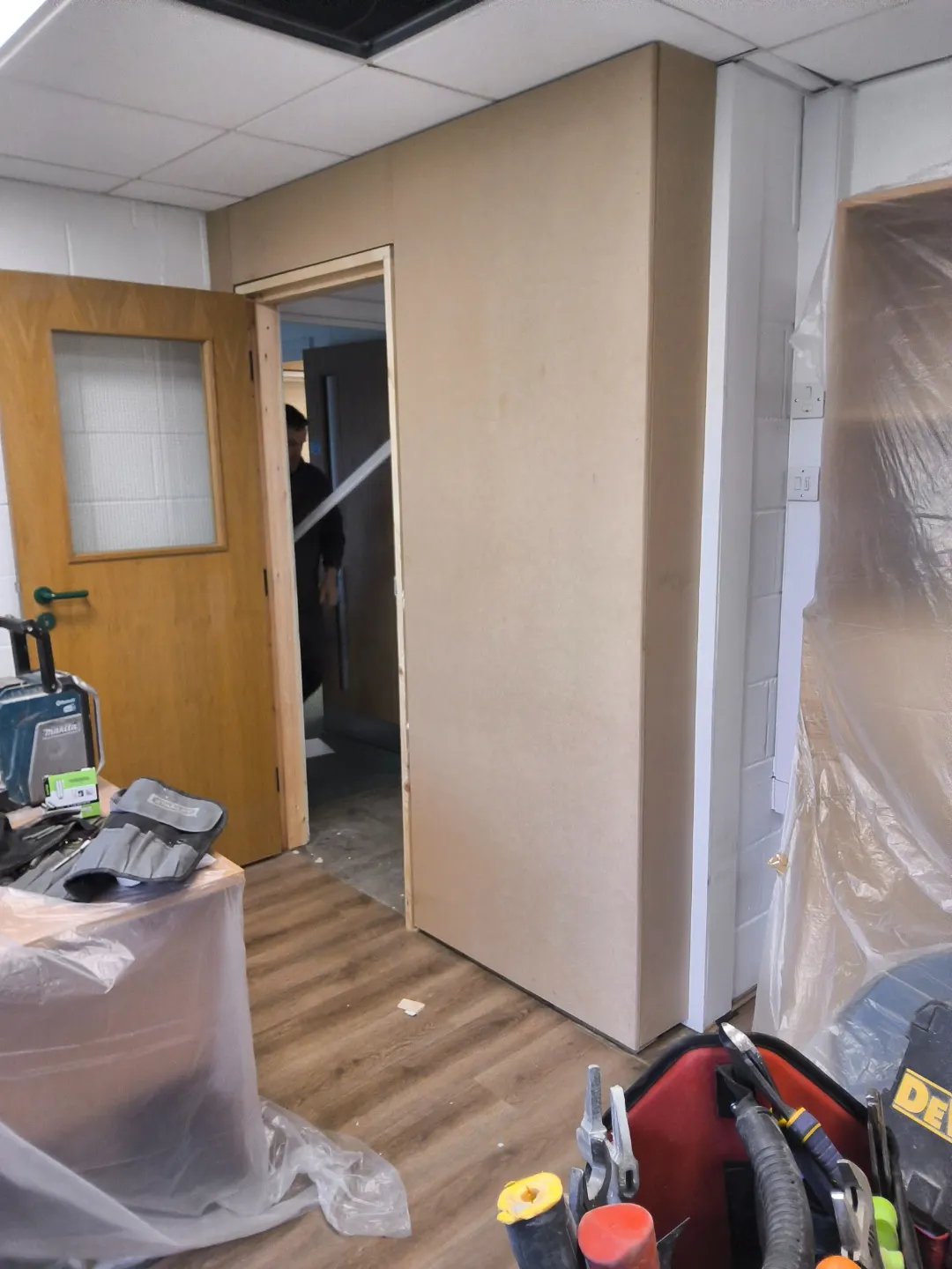 Partition lined out with sheet board and a new door opening formed through to the corridor.